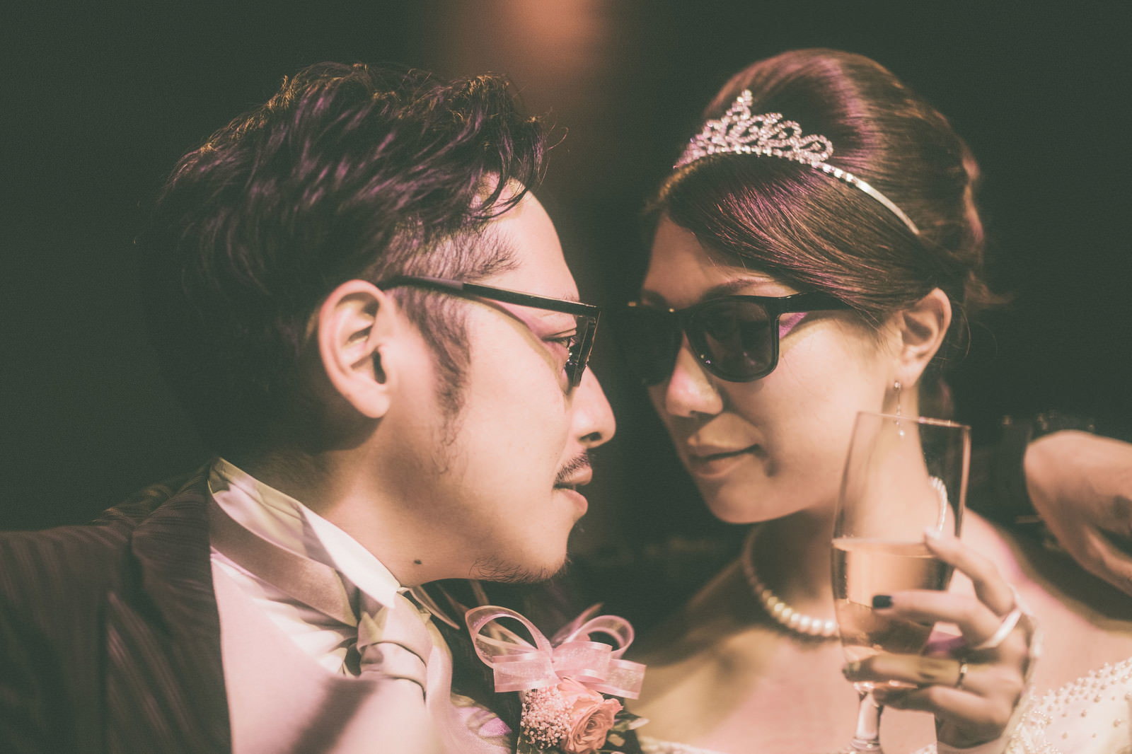 眼鏡の新郎とサングラスの新婦が夜に向き合うシーン
