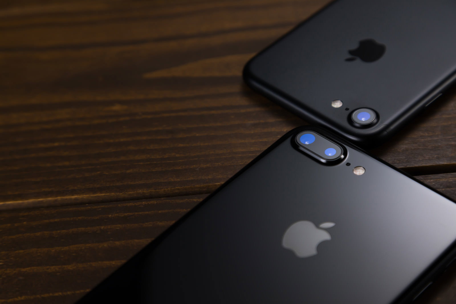 木製テーブルの上にiPhone2台を背面から撮影