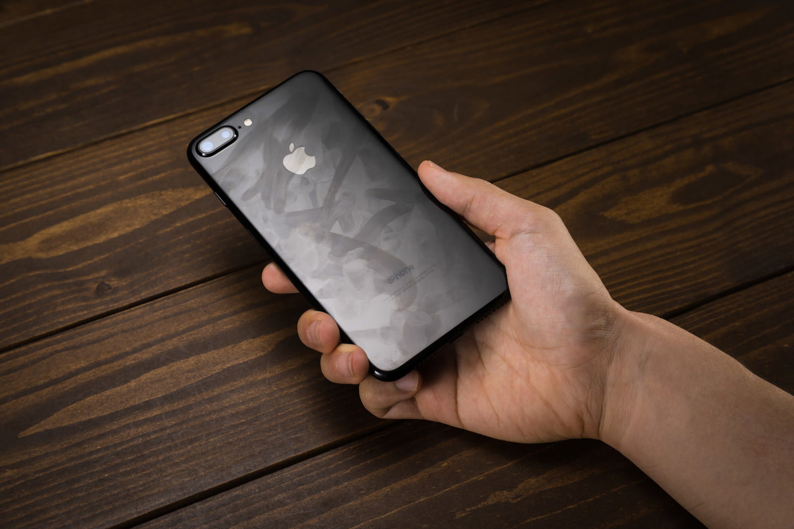 黒いiPhoneの背面を手に持っている