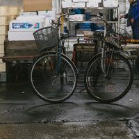 築地市場の割れたアスファルトに置かれた年期の入った自転車の写真