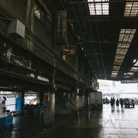 老朽化が進む築地市場の卸売場内部の鉄骨天井と濡れたコンクリート床の写真