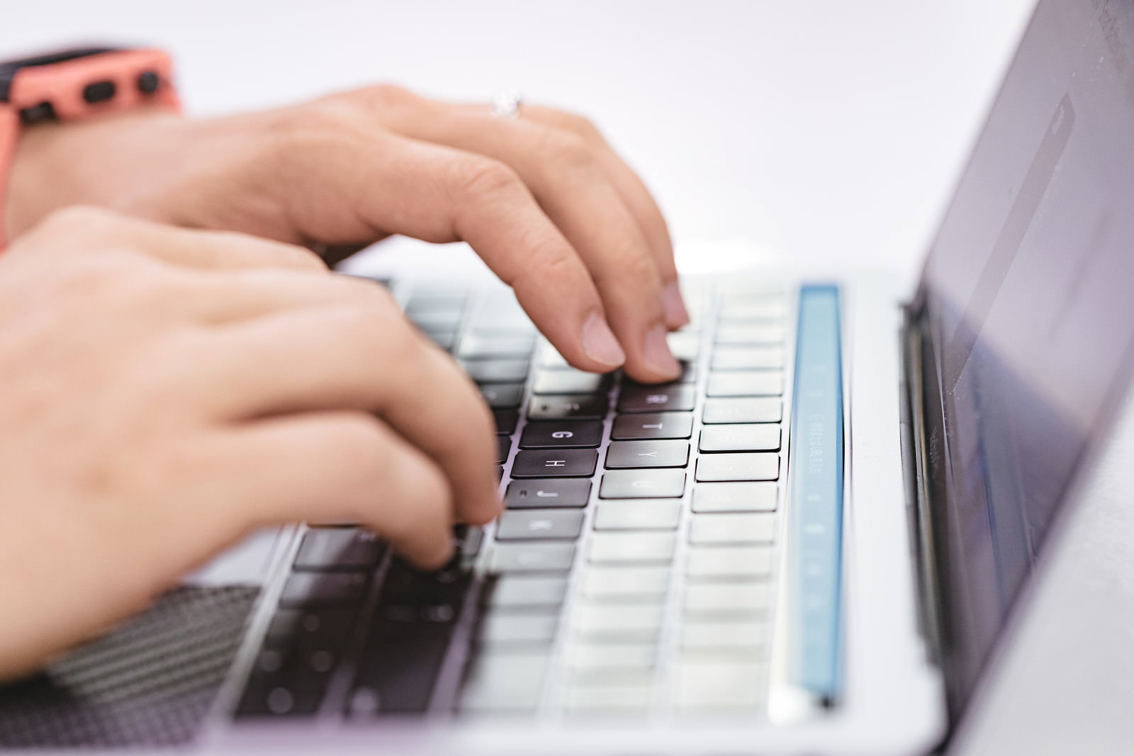 ノートパソコンのキーボードを打つ人の手元