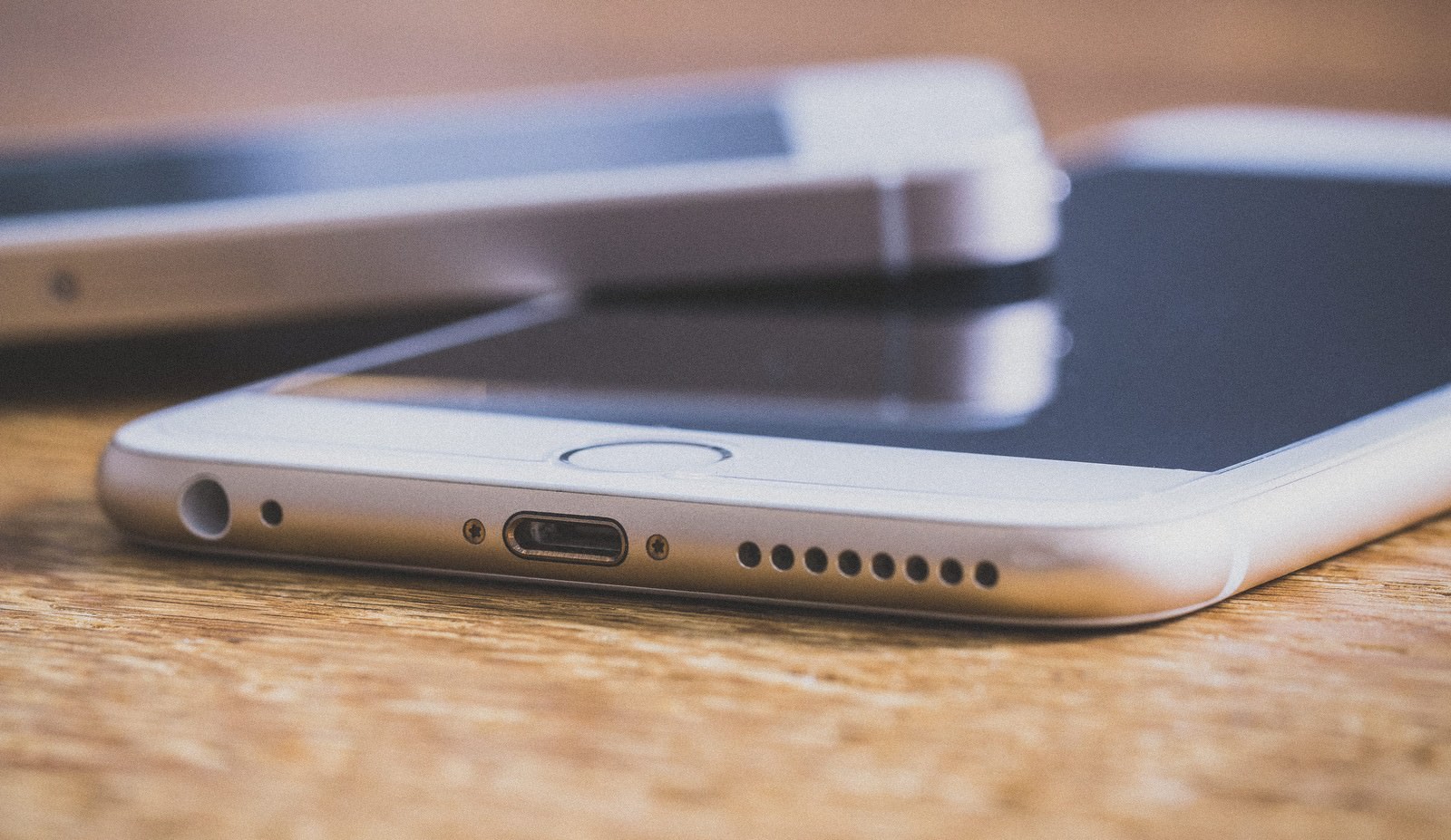 木目テーブルの上に重なって置かれた2台のスマートフォン