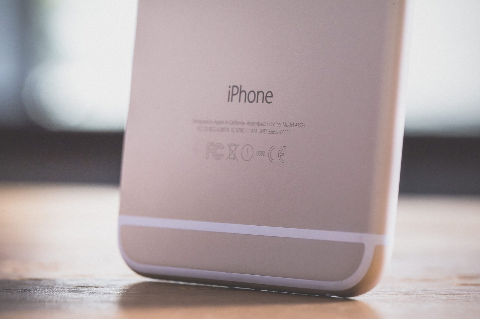 木製テーブルの上に立てたiPhoneの背面