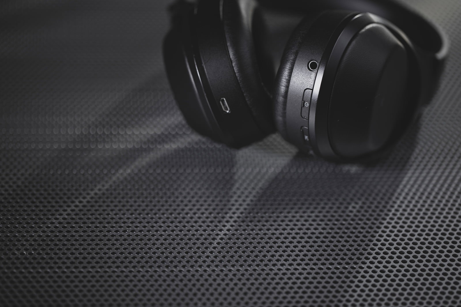 黒いワイヤレスヘッドフォンのボタンと充電口を斜め撮影