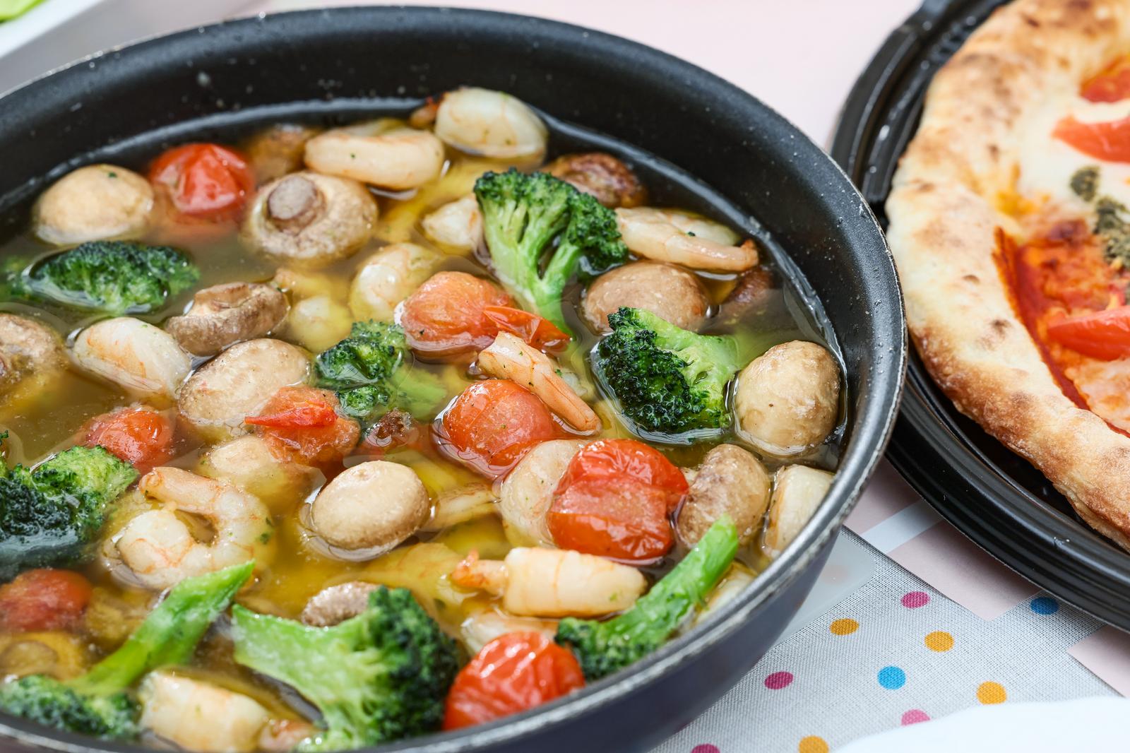 黒いスキレットに入ったマッシュルームとエビのアヒージョ