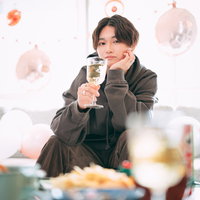 シャンパングラスを掲げる若い男性の写真