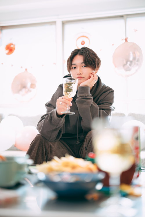 シャンパングラスを片手にホームパーティーで乾杯する男性