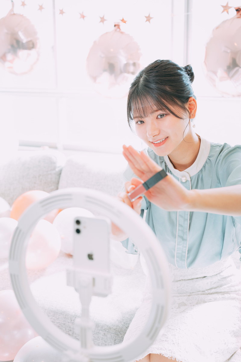 コスメアイテムを手に持って紹介している配信者の女性［モデル：モデルリリース］