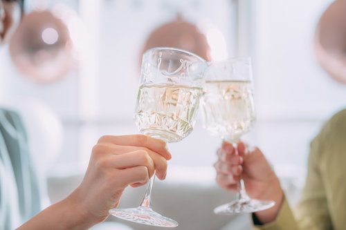 複数の手が持ち上げたシャンパングラスで乾杯
