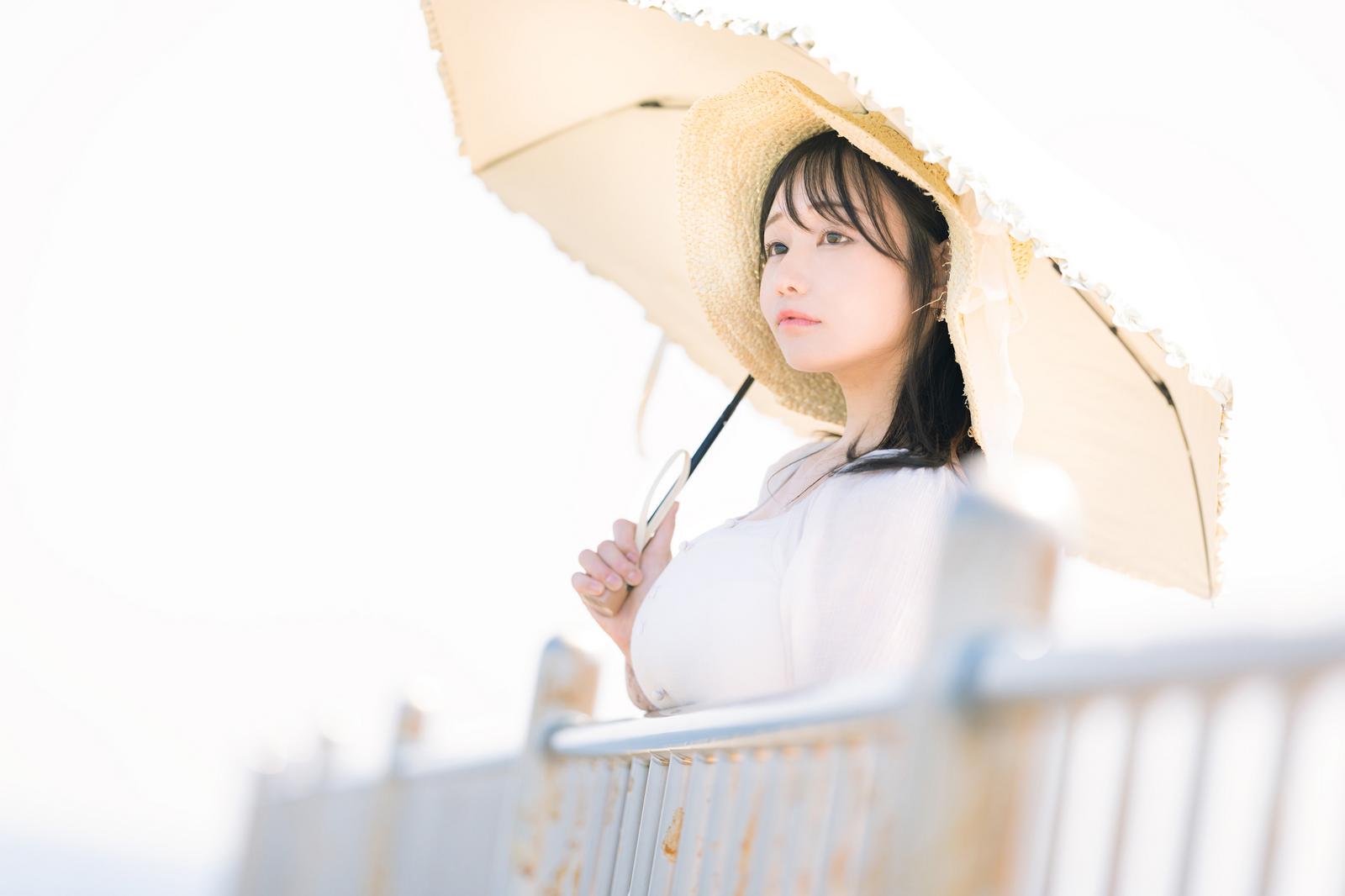 展望デッキで日傘をさして東京湾を眺める麦わら帽子の女性［モデル：茜さや］