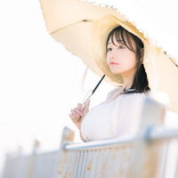 展望デッキから東京湾の景色を眺める日傘姿の女性の写真