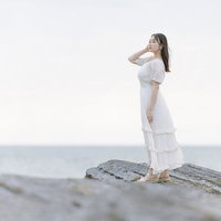 岩礁でポートレート（海辺・白ワンピース）の写真