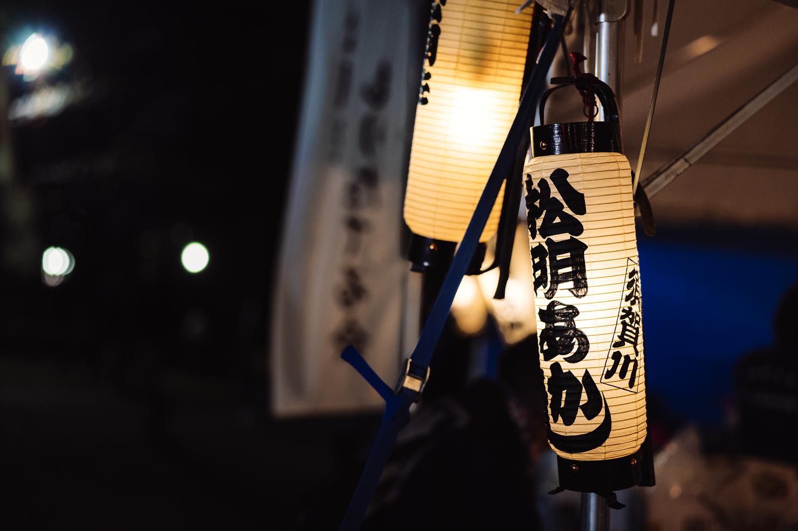 Nighttime scene of paper lanterns lit by torchlight
