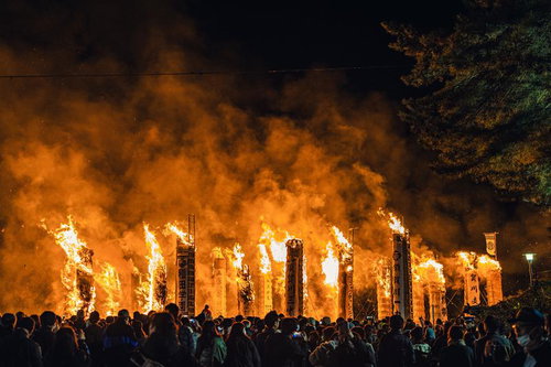 燃え上がる大松明の炎を見つめる観客たち