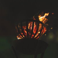 暗がりに浮かび上がる木炭の炎の写真
