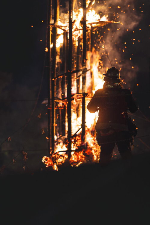 炎の光によって幻想的に浮かび上がる消防隊員のシルエット