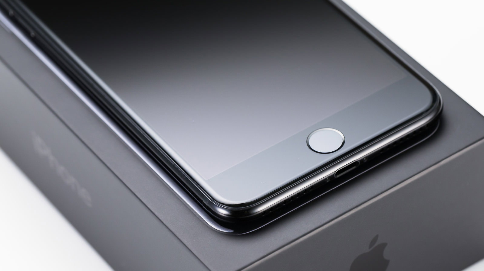 箱の上に置かれたiPhoneのホームボタンと下部のクローズアップ