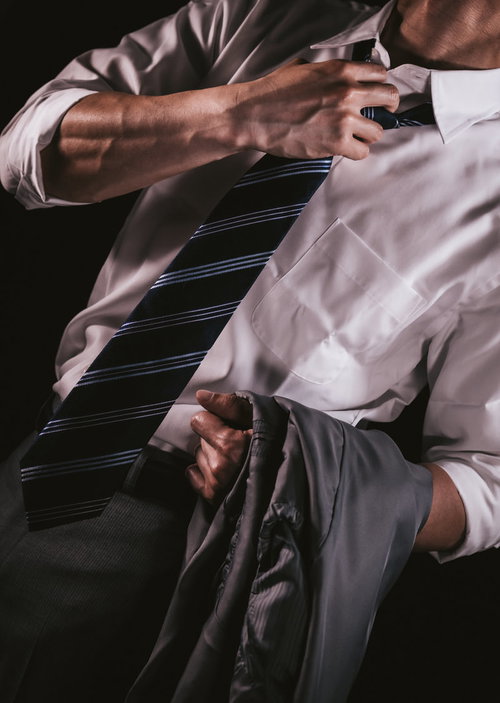 上着を脱いで暑さをアピールする男性の血管