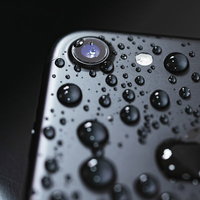防水性能を示す水滴まみれのiPhone、ガジェットレビュー向け写真の写真