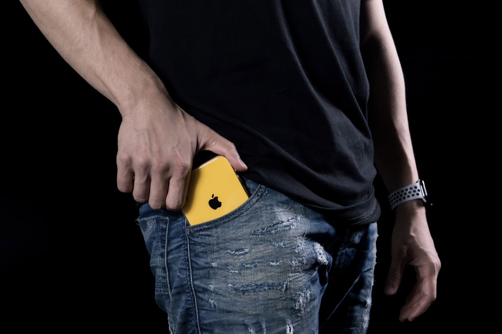 デニムパンツのポケットに黄色いiPhoneXRを入れている手