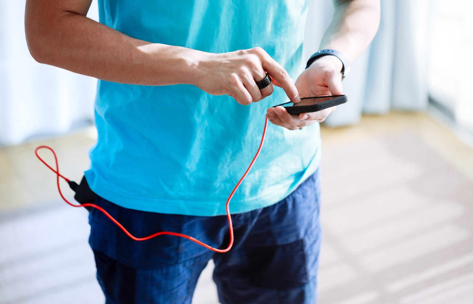 充電しながらスマホゲームをする男性
