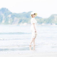 波打ち際を歩く白いワンピース姿の女性と夏の思い出の写真