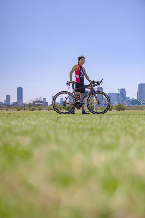 競技用ロードバイクを押しながら歩くトライアスロンの男性選手