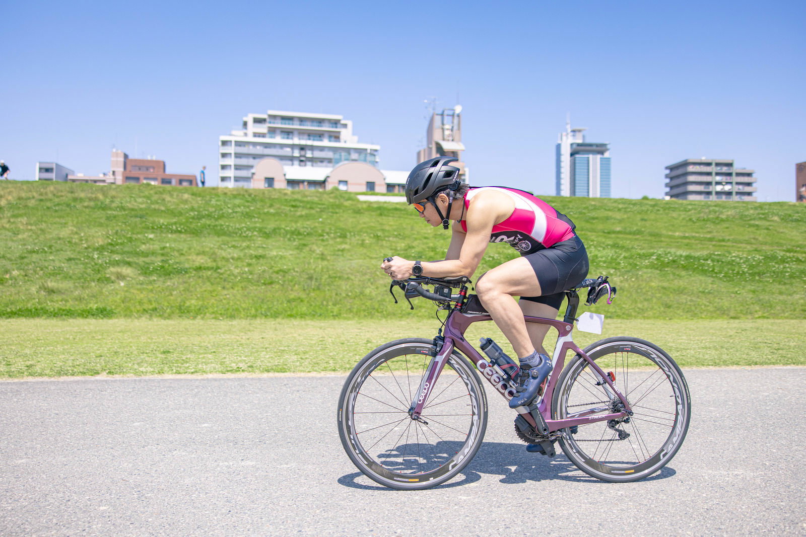 ピンクのウェアでロードバイクを走行する男性［モデル：うえせい］