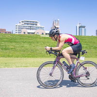 ピンクのウェアで走行するロードバイカーの男性の写真