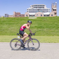 水分補給をしながら走行するトライアスロン選手の男性の写真