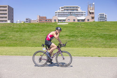 水分補給をしながら走行するトライアスロン選手の男性