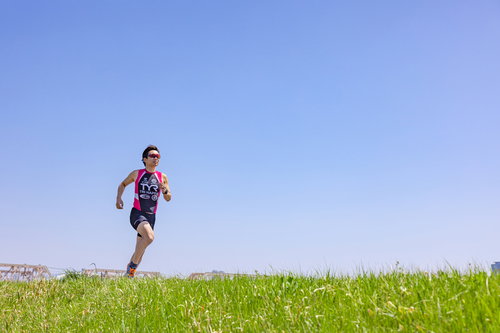 草原を走るトライアスロン選手の男性ランナー