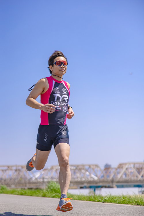 サングラスをかけて走るトライアスリート男性選手