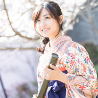 紺色の袴と花柄の着物で微笑む卒業生の春姿の写真