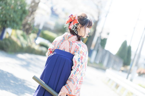 卒業証書を持った紺色袴姿の女性の後ろ姿