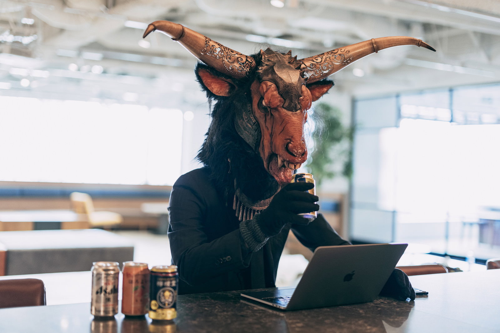 悪魔の仮面を被った人物がパソコンでオンライン飲み会をしている様子