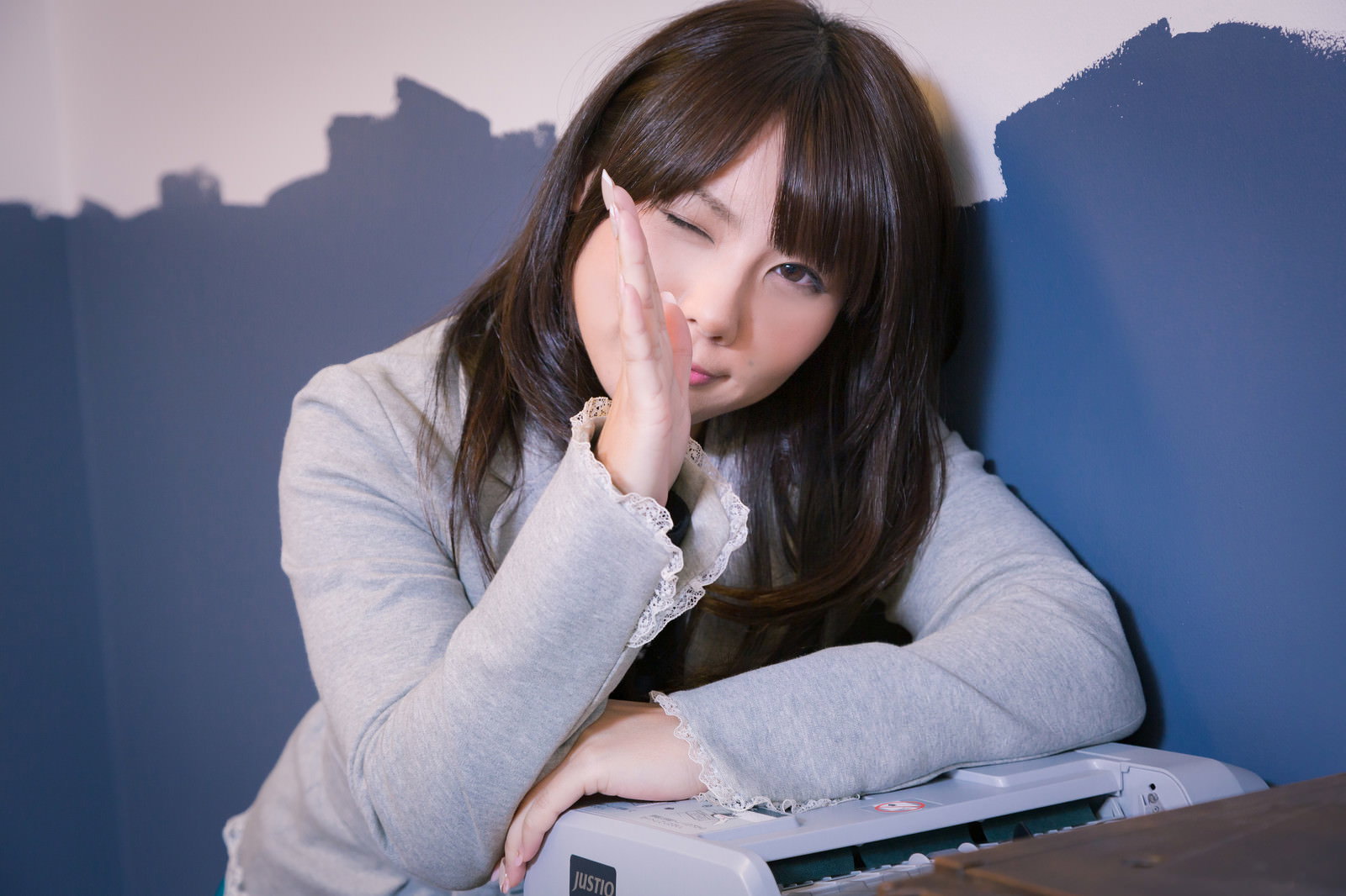 両手を合わせてお願いポーズをする女性［モデル：Lala］
