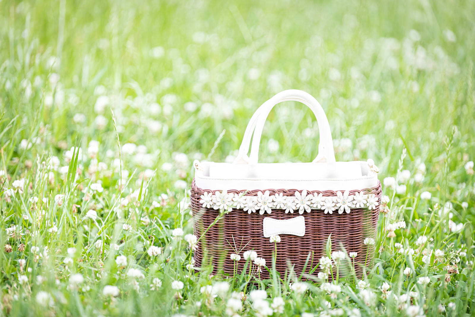 Wicker bag with lace decoration in a clover meadow