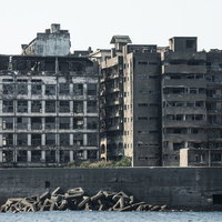 海上から見る軍艦島の70号棟端島小中学校跡と端島保育園跡の写真