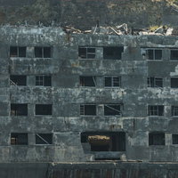 崩れた窓が不気味に残る軍艦島31号棟のコンクリート造廃墟建造物の写真