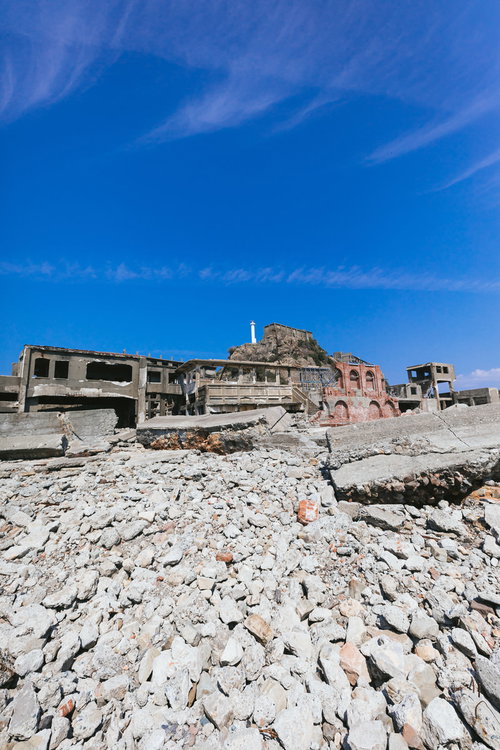 端島炭鉱総合事務所跡越しの肥前端島灯台（軍艦島）