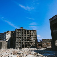 第三見学広場から見る軍艦島の日給社宅と肥前端島灯台の写真