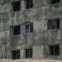 海に面して朽ち果てた日給社宅の窓（軍艦島）の写真