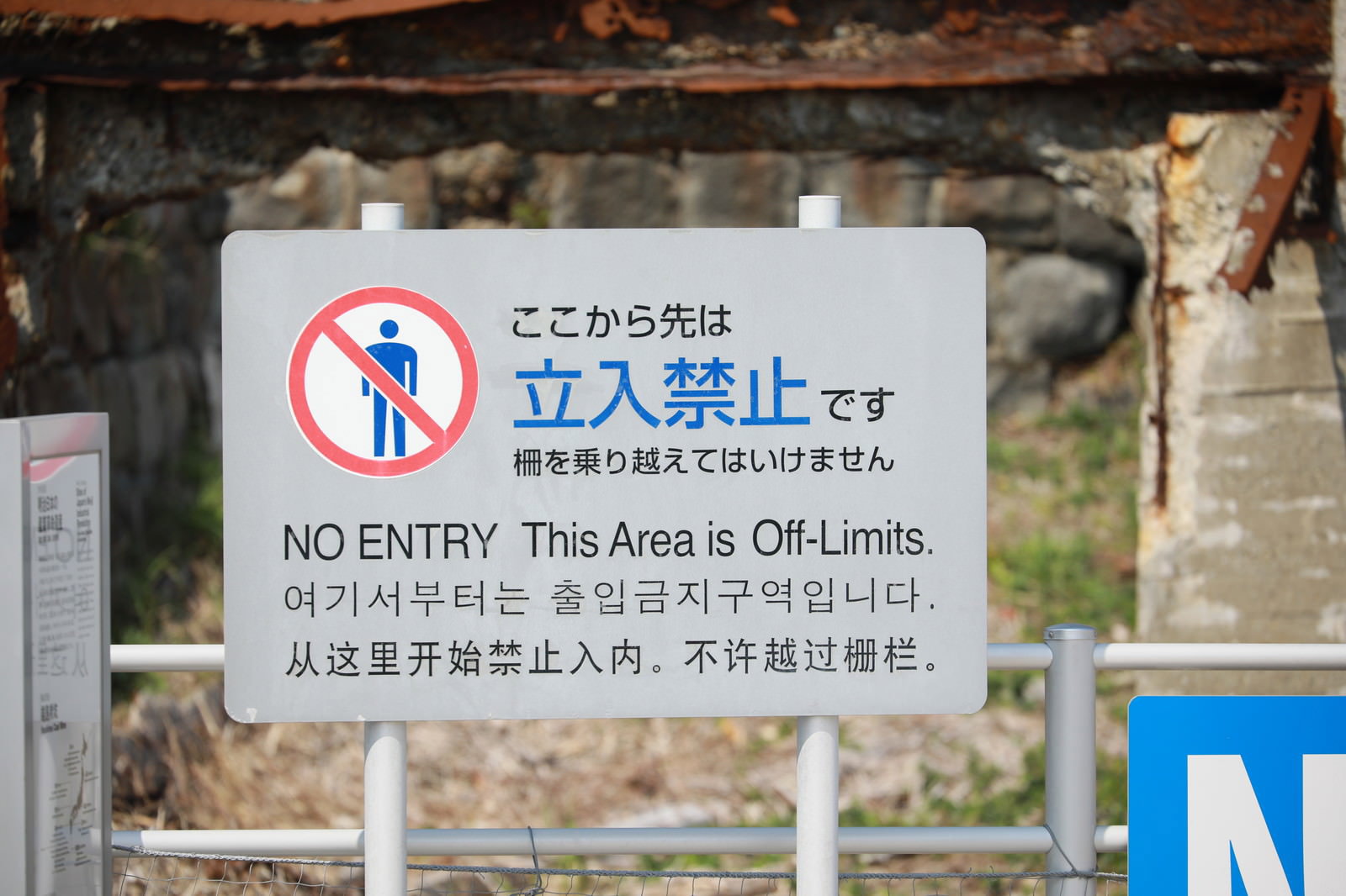 軍艦島のコンクリート壁に設置された立入禁止の多言語警告板