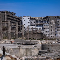 貯炭場から見る70号棟小中学校跡と世界遺産軍艦島の写真
