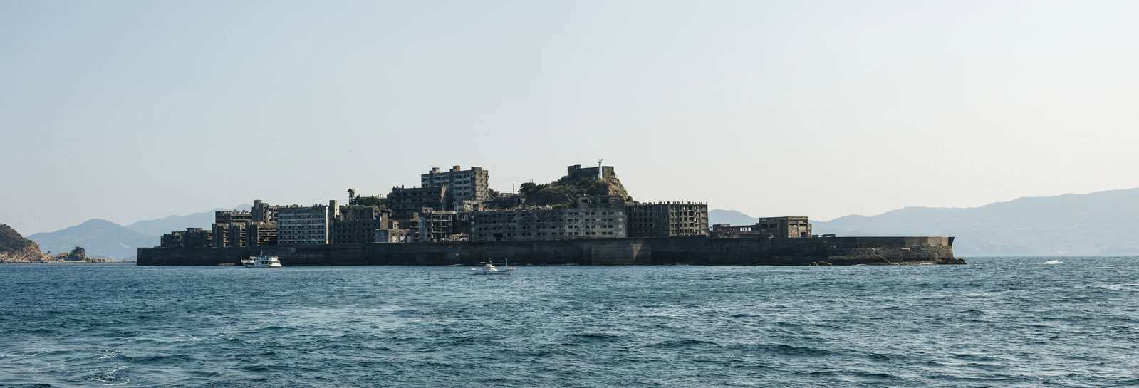 海に浮かぶ軍艦島（端島）の全景を遠方から撮影した様子