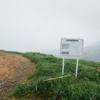 毛無峠の山地災害危険地区を示す警告看板と山間部の風景の写真