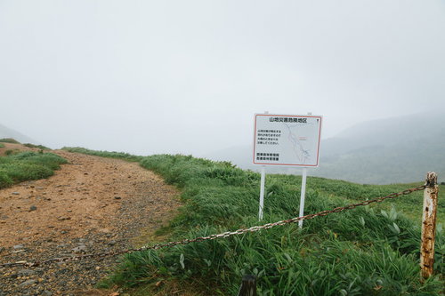 毛無峠の山地災害危険地区を示す警告看板と山間部の風景