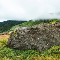 毛無峠の巨大な岩と雲海に包まれた山々の秋景観の写真